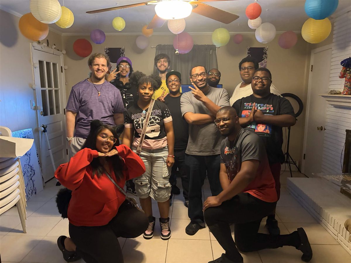 A group of club members smiling and posing for a photo at an indoor meetup